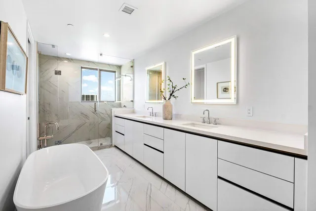 a bathroom with a double vanity sink toilet mirror and bathtub