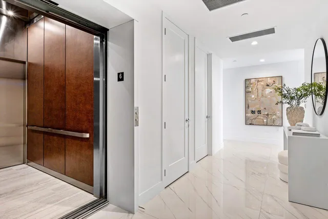 a view of a hallway with closet and mirror