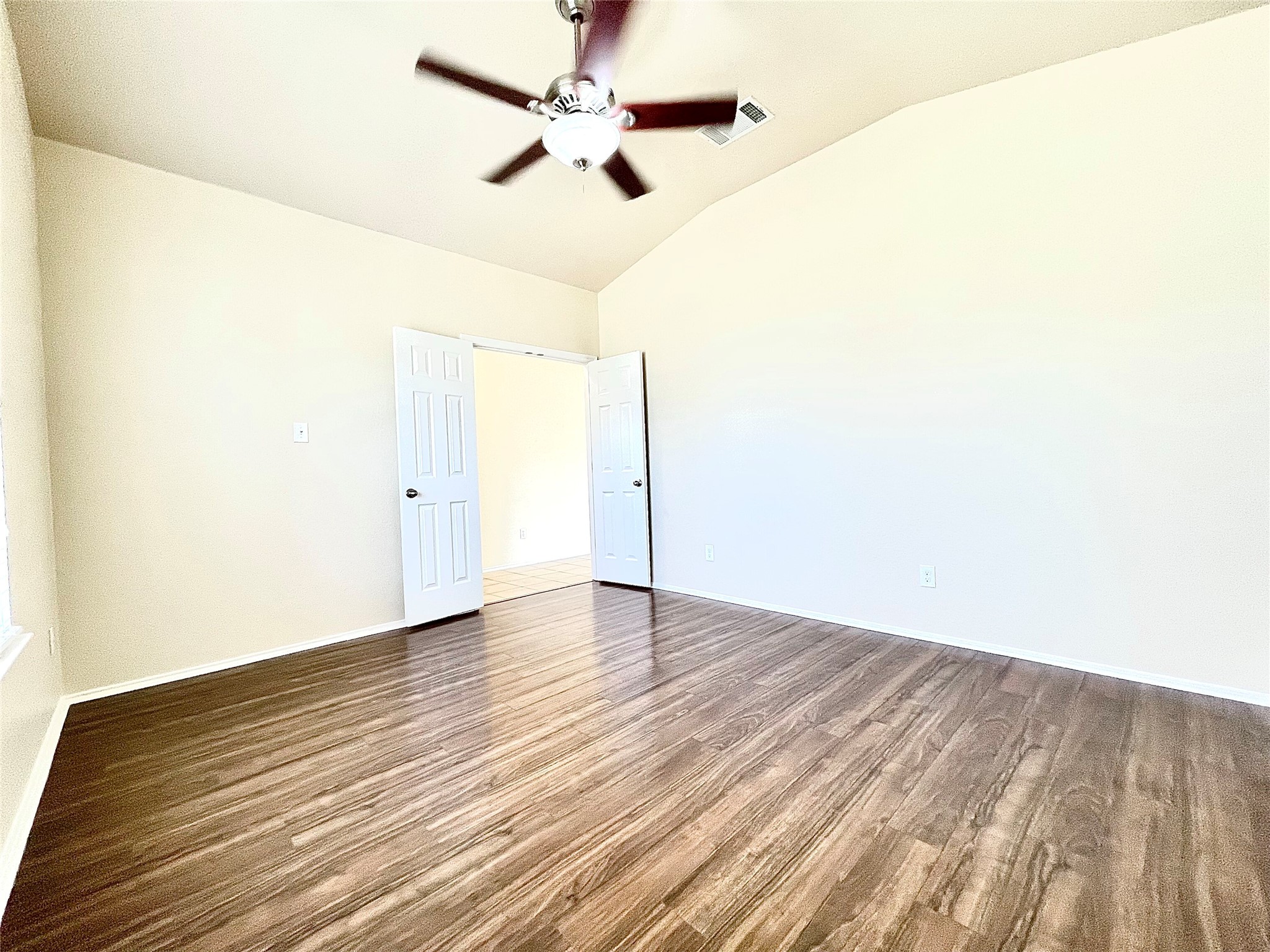508 Emma Rose Trail Leander, TX 78641 - Photo 28 of 40 A spacious room with elegant wood flooring and a vaulted ceiling with a fan.