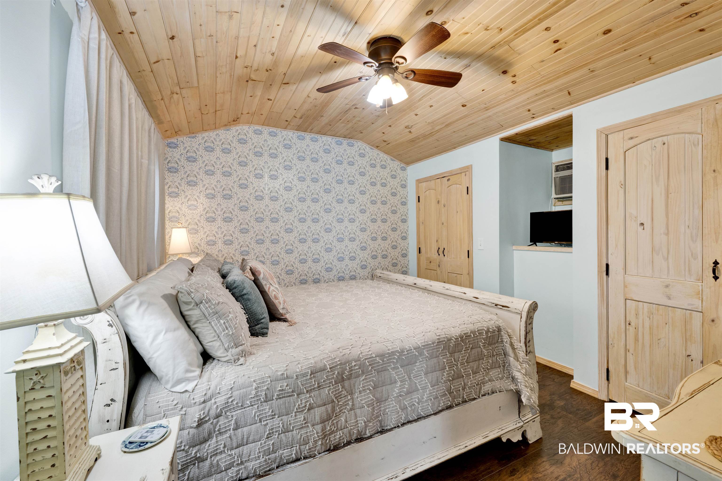 23770 Miflin Road Elberta, AL 36530 - Photo 31 of 38 Bedroom with vaulted ceiling, wooden ceiling, ceiling fan, wallpapered walls, and dark wood-style flooring