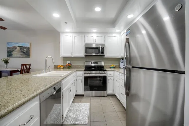 a kitchen with stainless steel appliances granite countertop a stove a refrigerator and a sink