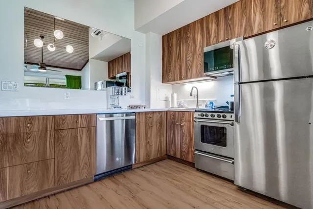 a kitchen with granite countertop a refrigerator stove and microwave