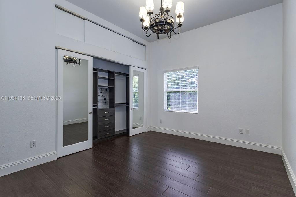 4800 Southwest 141st Avenue Miramar, FL 33027 - Photo 21 of 90 an empty room with wooden floor chandelier and windows