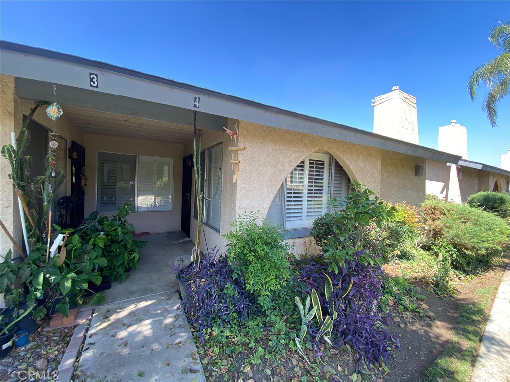 2891 Canyon Crest Drive, Unit 4 Riverside, CA 92507 - Photo 1 of 1 a front view of a house with garden