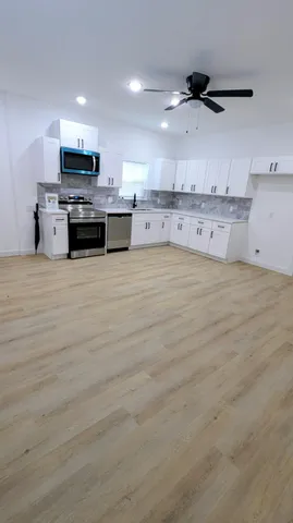 a large kitchen with stainless steel appliances granite countertop a stove and a sink