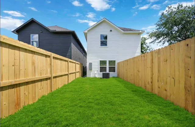 a view of a backyard with wooden fence