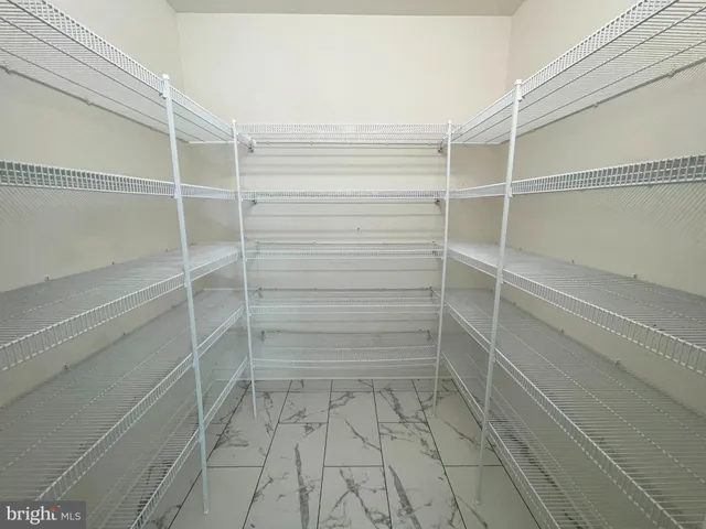 an empty room with windows and chandelier fan