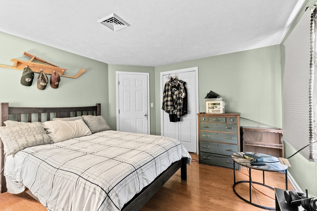 21 Chowdermarch Street Marshfield, MA 02050 - Photo 25 of 39 a bedroom with a bed and wooden floor