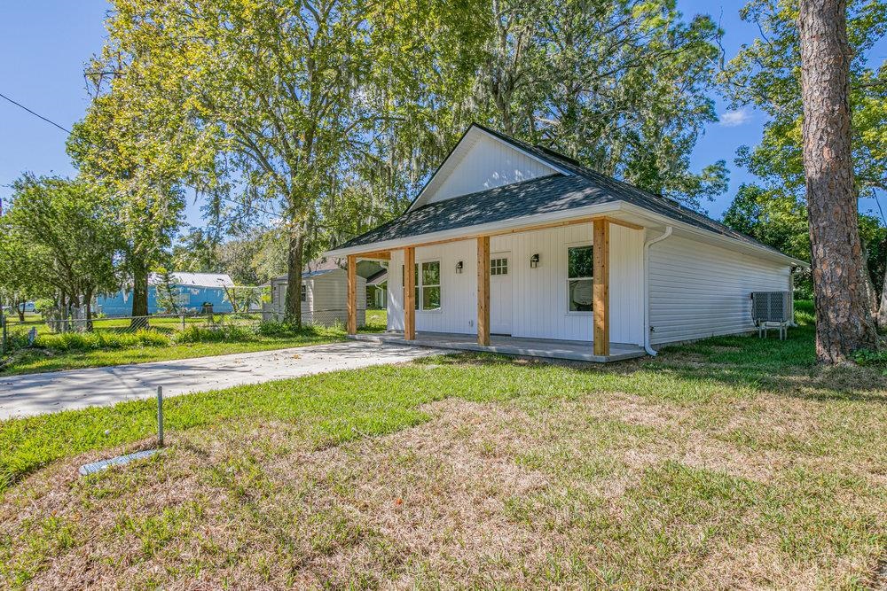 a view of a house with backyard and trees