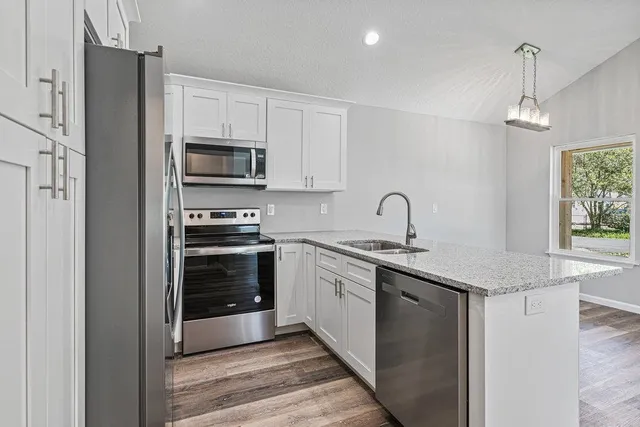 a kitchen with granite countertop a sink and stainless steel appliances