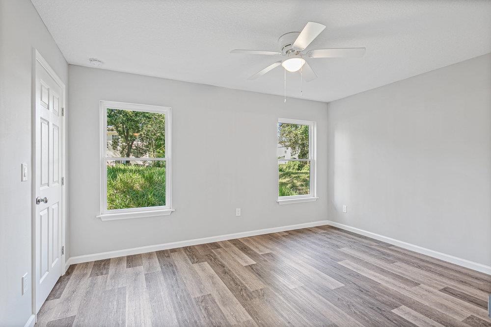 2885 North 8th Street St. Augustine, FL 32084 - Photo 22 of 35 an empty room with wooden floor ceiling fan and windows