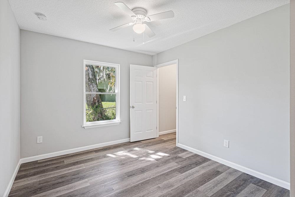 2885 North 8th Street St. Augustine, FL 32084 - Photo 24 of 35 an empty room with wooden floor ceiling fan and windows