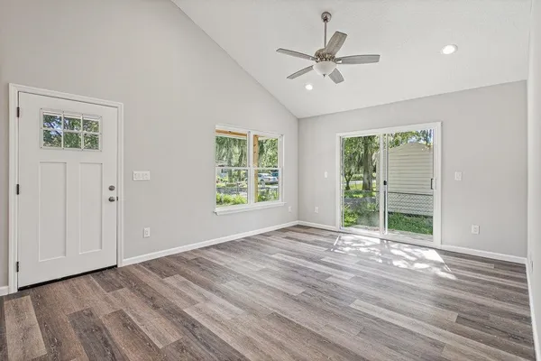 a view of an empty room with a window and wooden floor