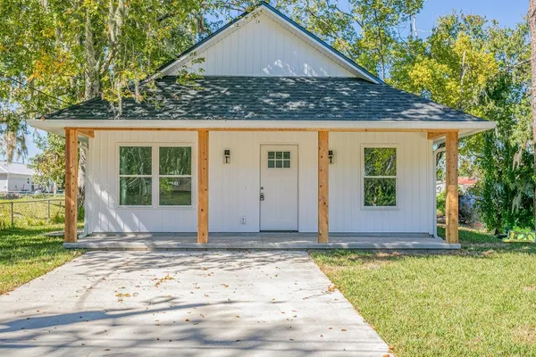a view of house with backyard and tree