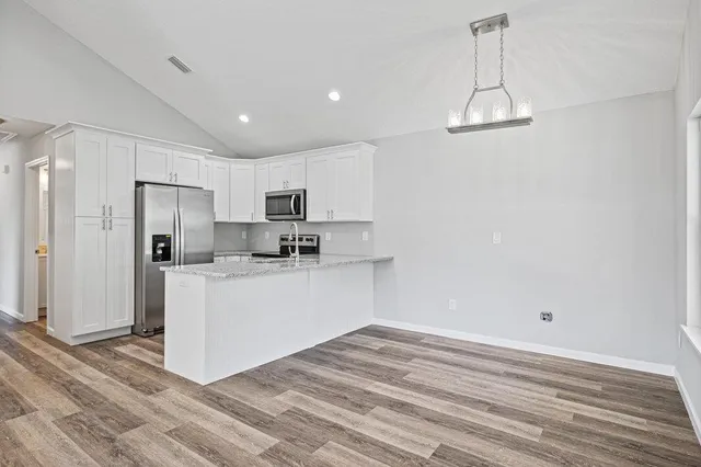 a view of kitchen with refrigerator microwave and cabinets