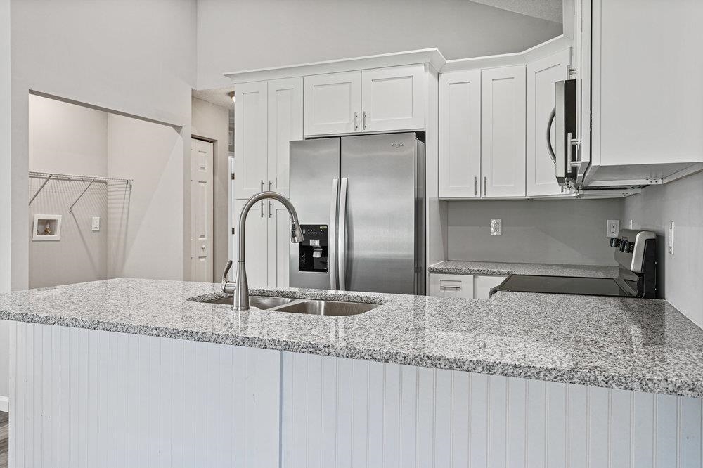 2885 North 8th Street St. Augustine, FL 32084 - Photo 9 of 35 a kitchen with granite countertop a refrigerator and a sink