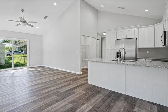 a view of a kitchen with a sink and dishwasher wooden floor