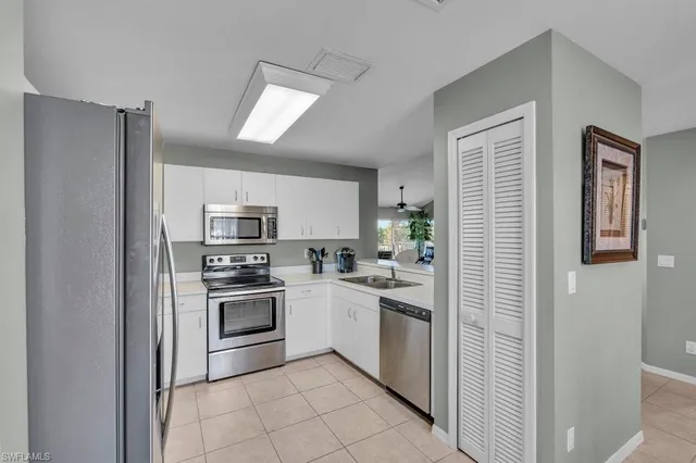 a kitchen with cabinets stainless steel appliances and window