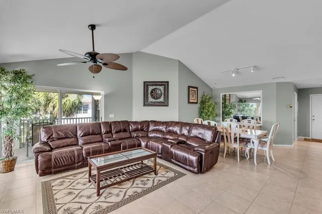 a living room with furniture ceiling fan and a window