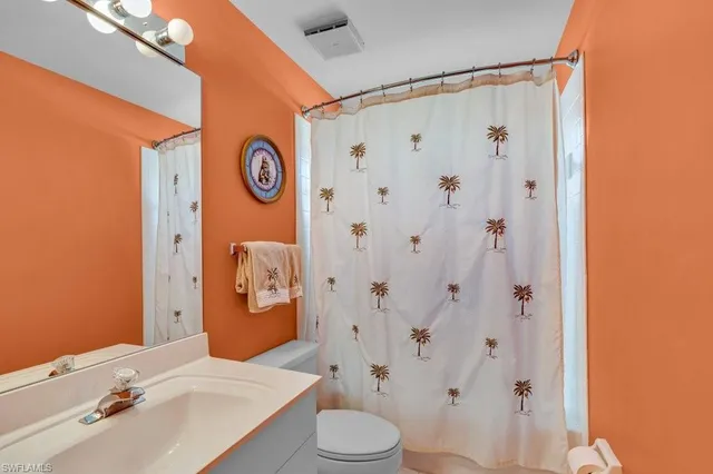 a bathroom with a sink a toilet and shower curtain