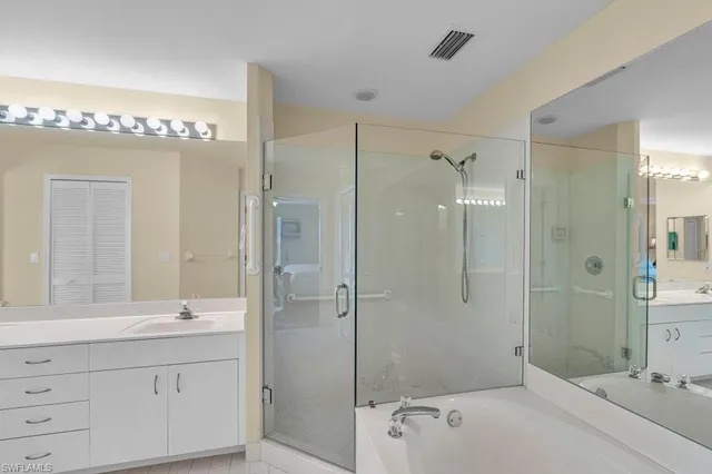 a bathroom with a tub shower sink mirror and shower