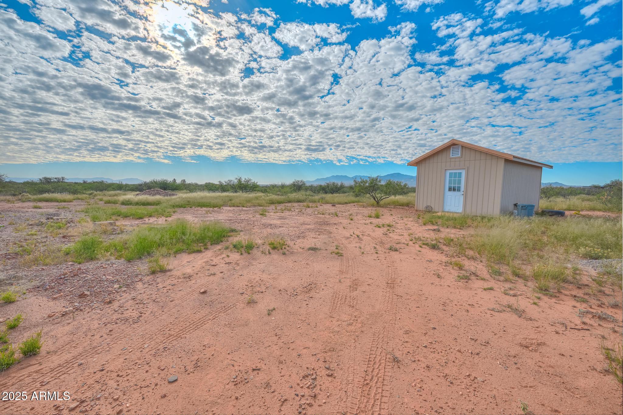 988 West El Rancho Boulevard, Unit B Huachuca City, AZ 85616 - Photo 13 of 13 a view of a dry yard with a barn