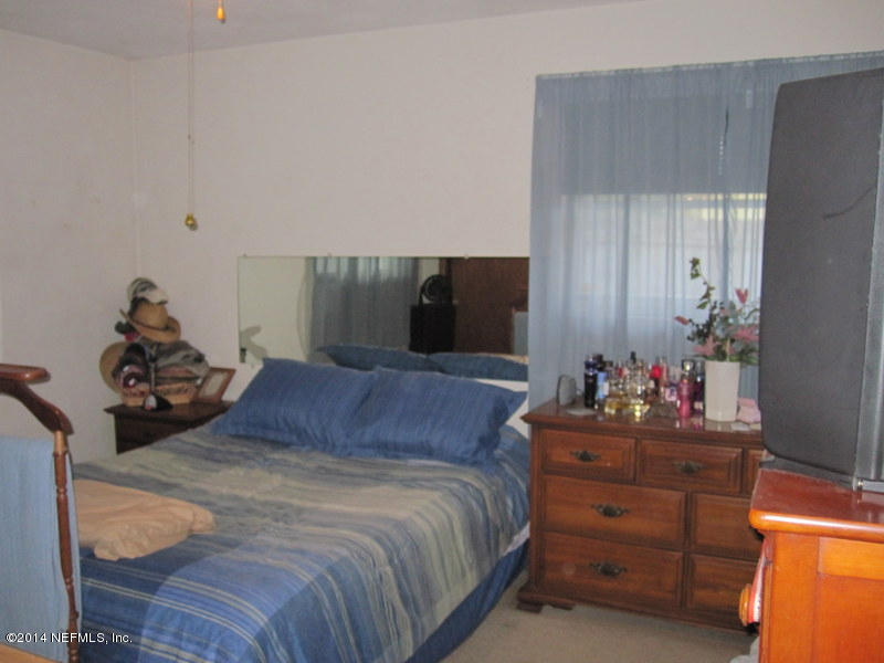 2618 Sam Road Jacksonville, FL 32216 - Photo 10 of 16 a bedroom with a bed and a dresser in it