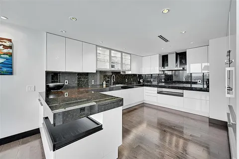 a kitchen with stainless steel appliances granite countertop a stove a sink and a refrigerator