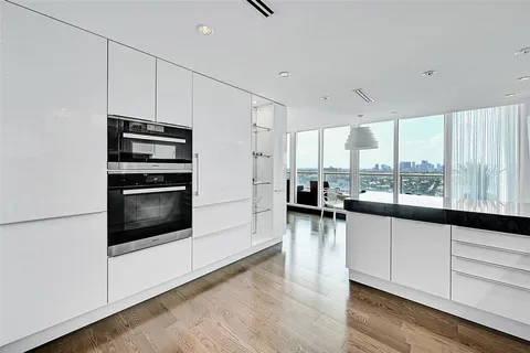 a kitchen with stainless steel appliances a stove a sink and white cabinets