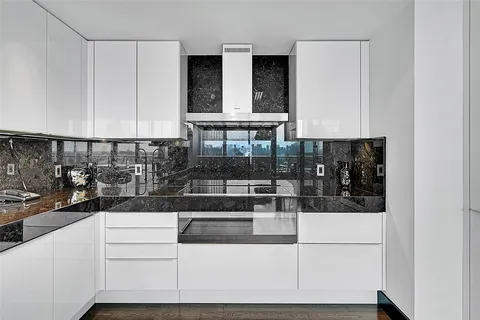 a kitchen with white cabinets and black appliances