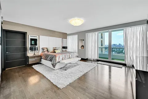 a bedroom with a bed and a large window