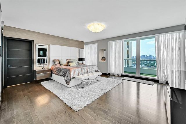 a bedroom with a bed and a large window