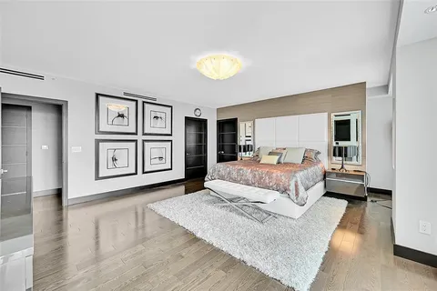 a spacious bedroom with a large bed and a chandelier