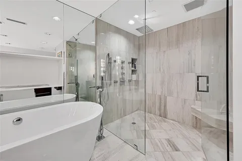 a bathroom with a tub a sink and a shower