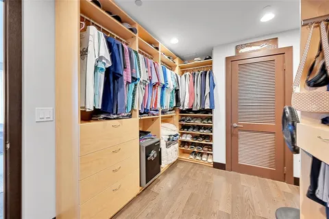 a view of walk in closet with clothes and shoes