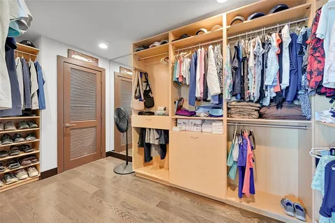 a view of walk in closet with clothes and shoes