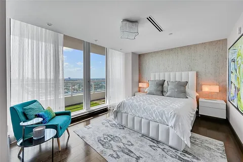 a bedroom with a bed and a large window