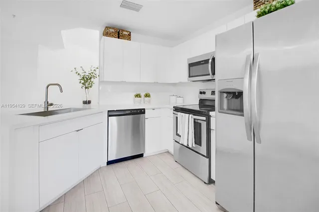 a kitchen with white cabinets stainless steel appliances and a counter top