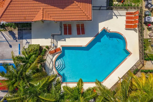 an aerial view of a house with swimming pool and porch