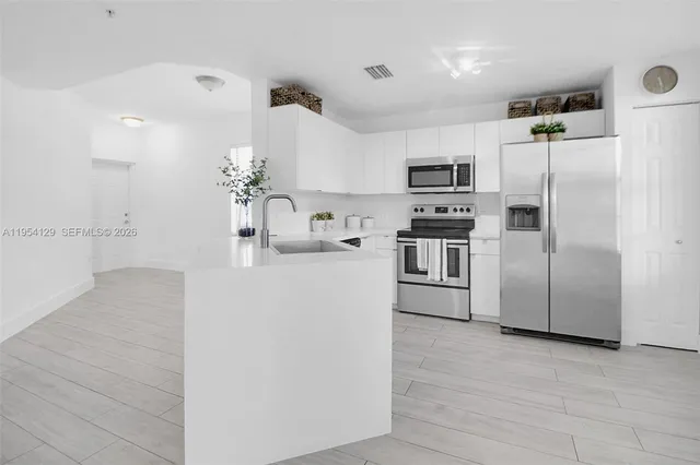 a kitchen with stainless steel appliances a refrigerator and a sink