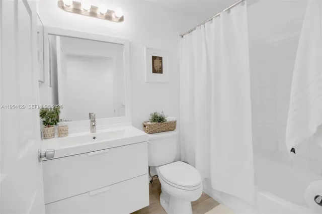 a bathroom with a sink toilet and a mirror