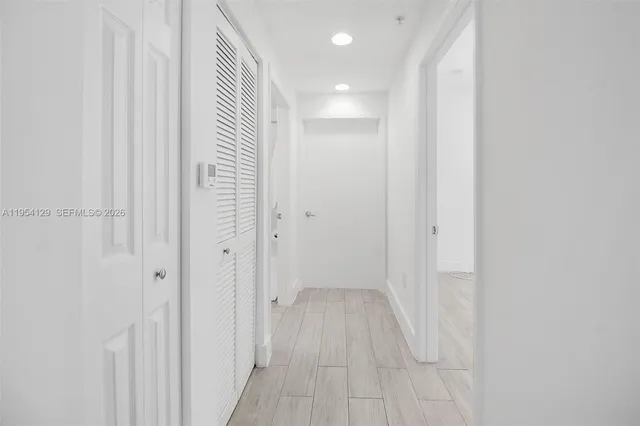 a view of a hallway with wooden floor