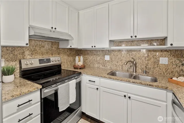 a kitchen with stainless steel appliances granite countertop a sink stove and cabinets