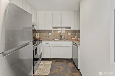 a dining hall with granite countertop white cabinets and a granite counter top