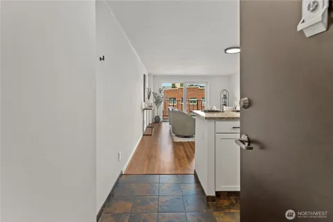 an empty room with wooden floor cabinet and windows