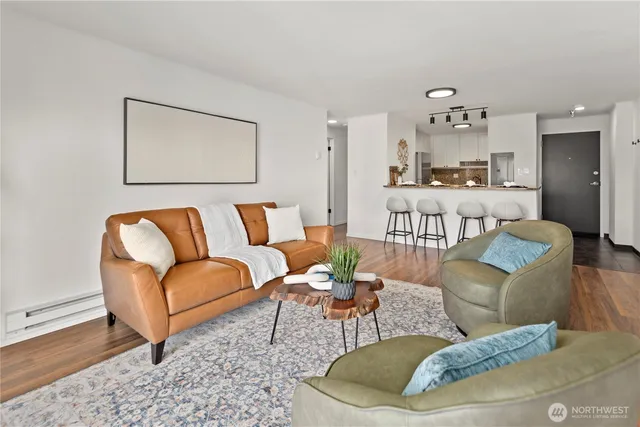 a living room with furniture a rug and kitchen view