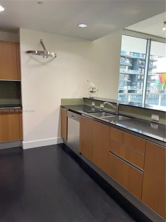 a kitchen with a sink and wooden floor