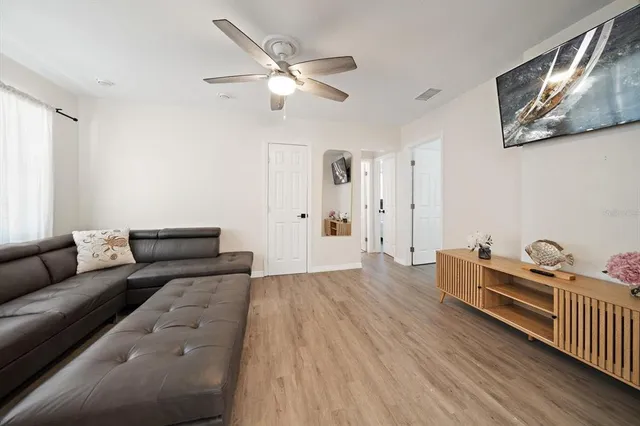 a living room with furniture and a wooden floor