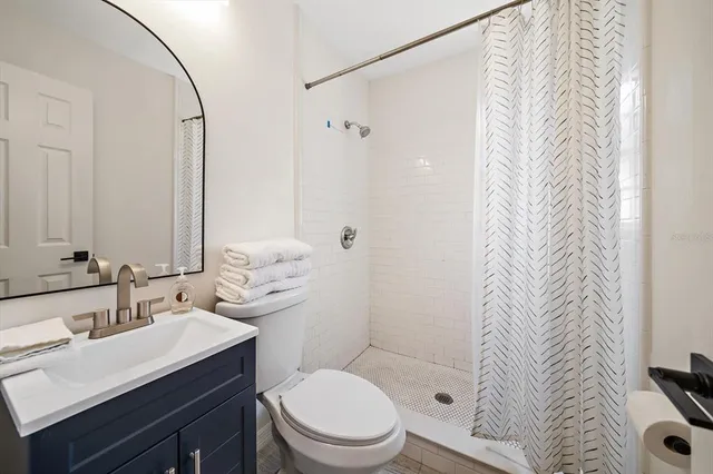 a bedroom with a bed a chair and a large window