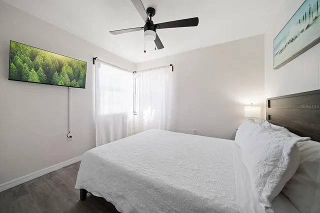 a bedroom with a bed and wooden floor